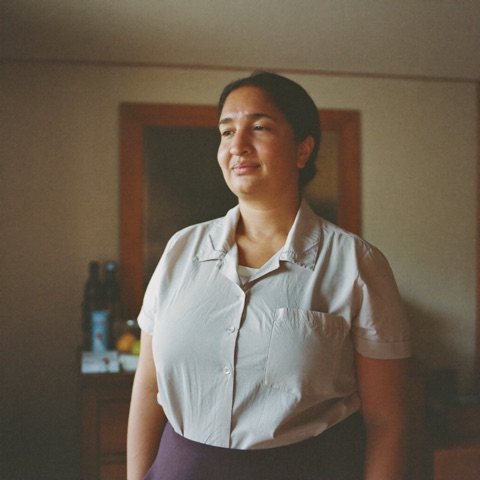 A bilingual carer in a home setting, illustrative.